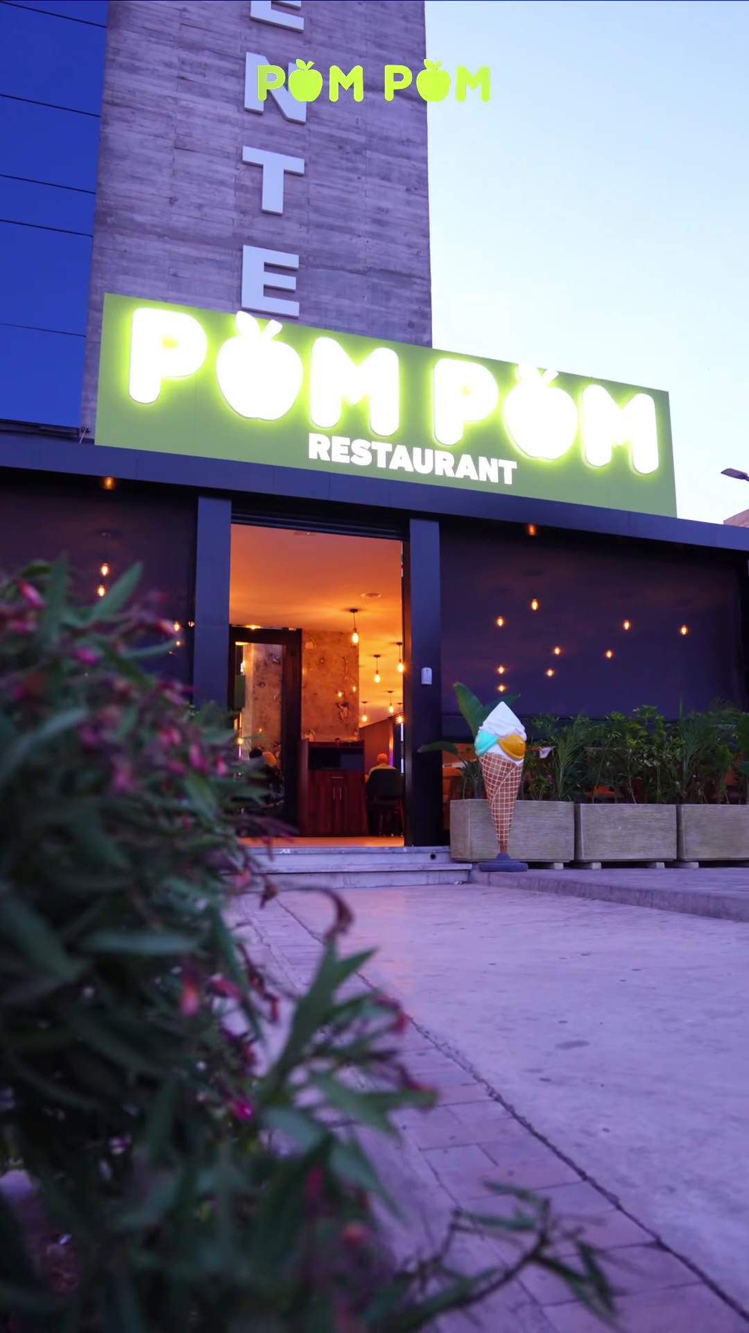 Entrée du restaurant Pom Pom illuminée la nuit